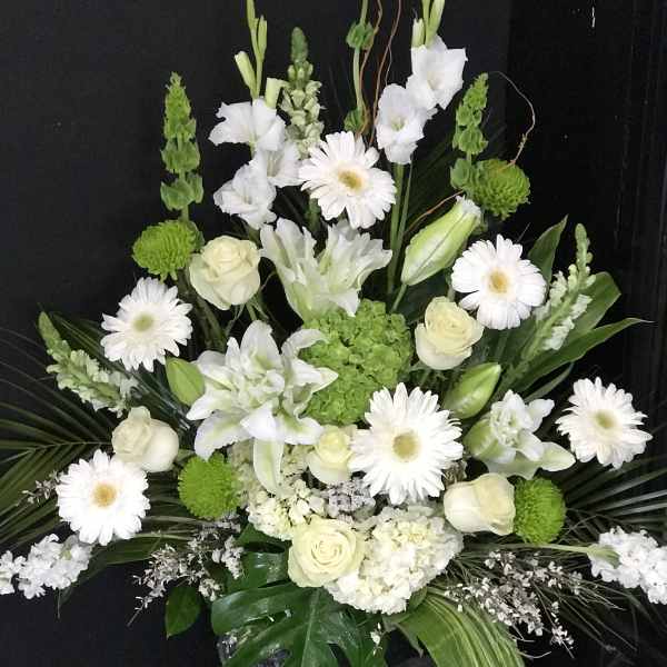 White and green floral arrangement with roses and daisies in a vase