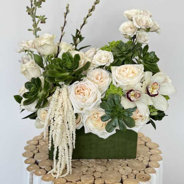 White roses and orchids in a green box with succulents