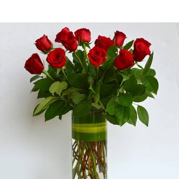 Red roses arranged in a tall glass vase
