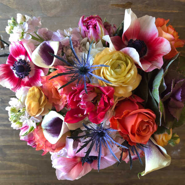 Mixed bouquet with pink anemones, roses, calla lilies, and blue thistle