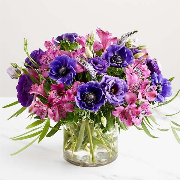 Purple and pink mixed bouquet in a clear glass vase