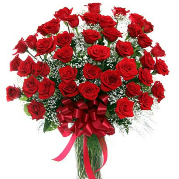 Bouquet of red roses in a glass vase with a red ribbon bow