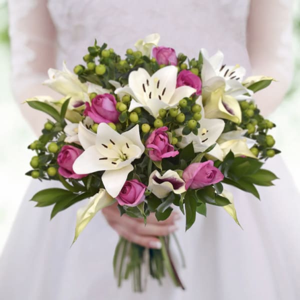 Bouquet of pink roses and white lilies with green berries