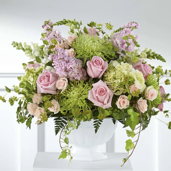 Pink roses and green chrysanthemums arranged in a white vase