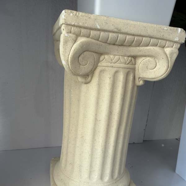 Beige decorative pedestal column with a fluted shaft and ornate top