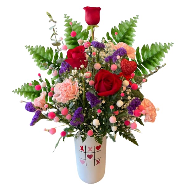 Red roses and pink carnations in a white vase with heart designs