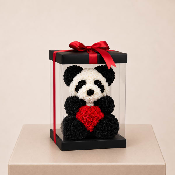 Panda-shaped floral gift in a clear box with a red ribbon and heart