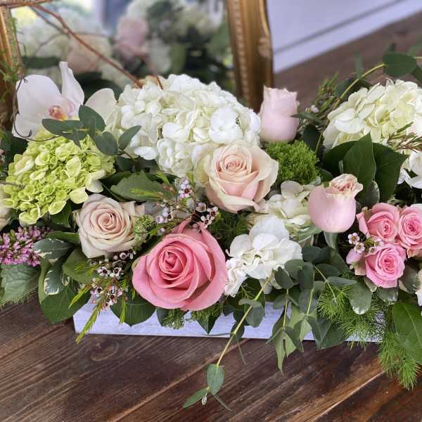 Pink and white roses with hydrangeas in a low rectangular arrangement