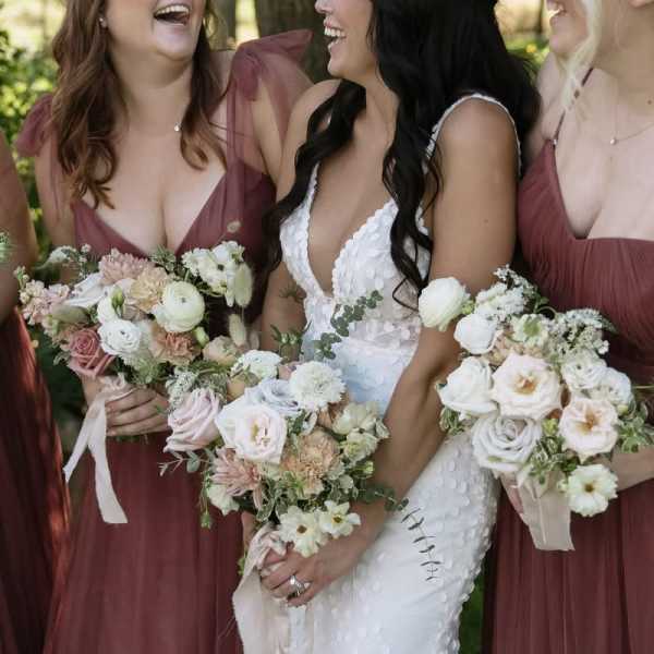 Bride and bridesmaids holding pastel wedding bouquets