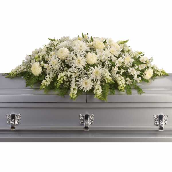 White floral casket spray on a silver casket