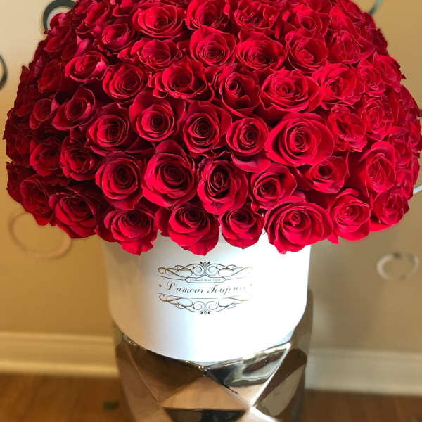 Large dome of red roses arranged tightly in a white hatbox container