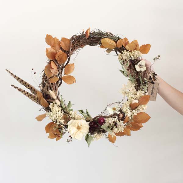 Autumn wreath with cream flowers and orange leaves