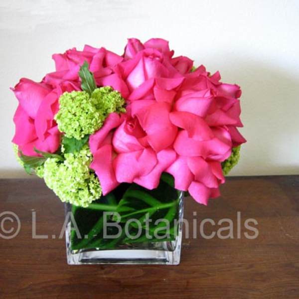 Pink rose bouquet with green hydrangea in a clear square vase