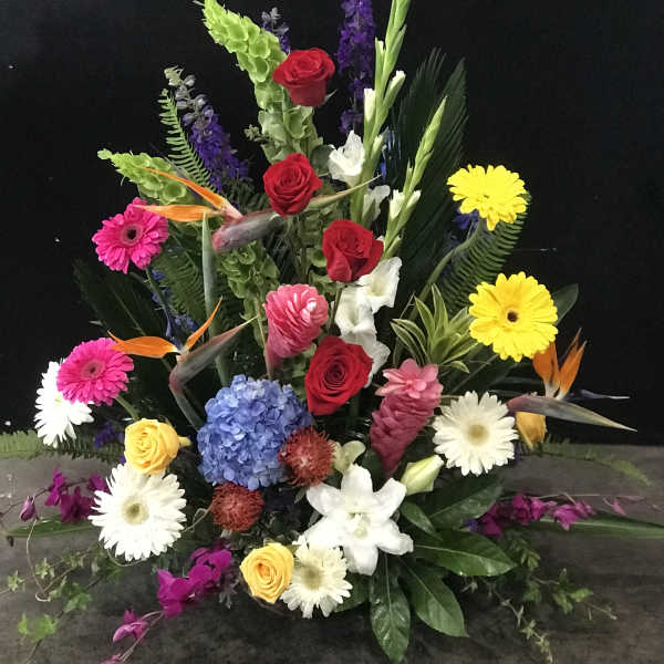 Colorful floral arrangement with roses, gerbera daisies, and birds of paradise