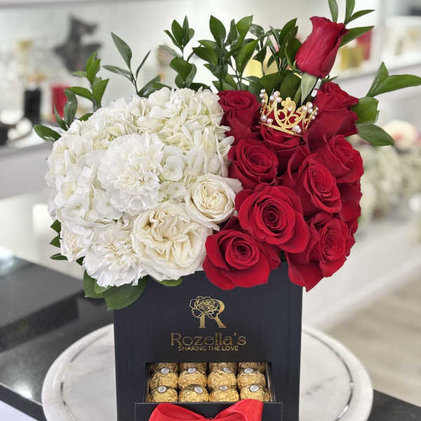 Red roses and white hydrangeas in a black gift box with chocolates