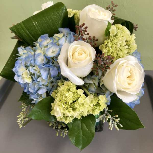 Bouquet of white roses and blue hydrangeas with green accents