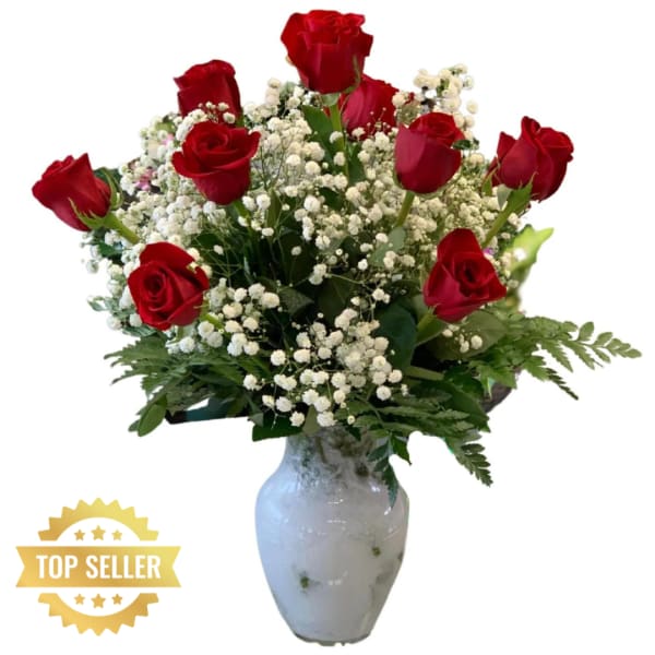 Red roses with white baby's breath in a white vase