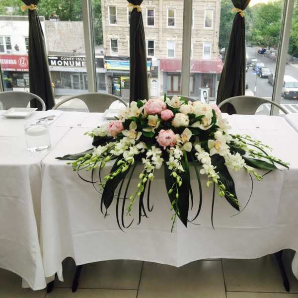 Low floral centerpiece with pink and white flowers on a table