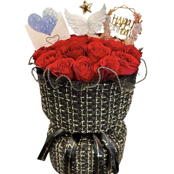 Red roses in a black woven gift wrap with a card and decorative toppers