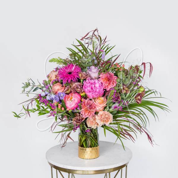 Large mixed bouquet in a glass vase with pink and peach flowers