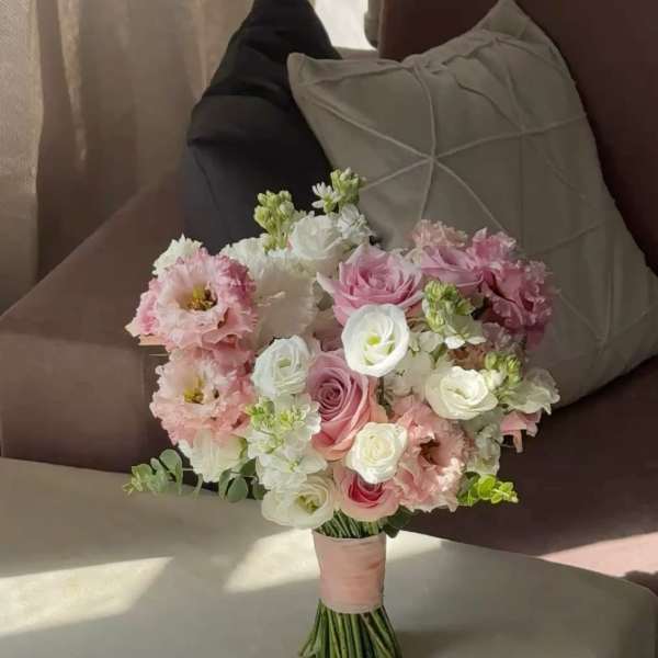 Pink and white bridal bouquet with roses and ruffled blooms
