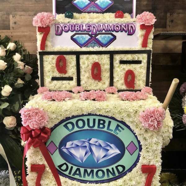 Floral display shaped like a slot machine with pink carnations and white flowers