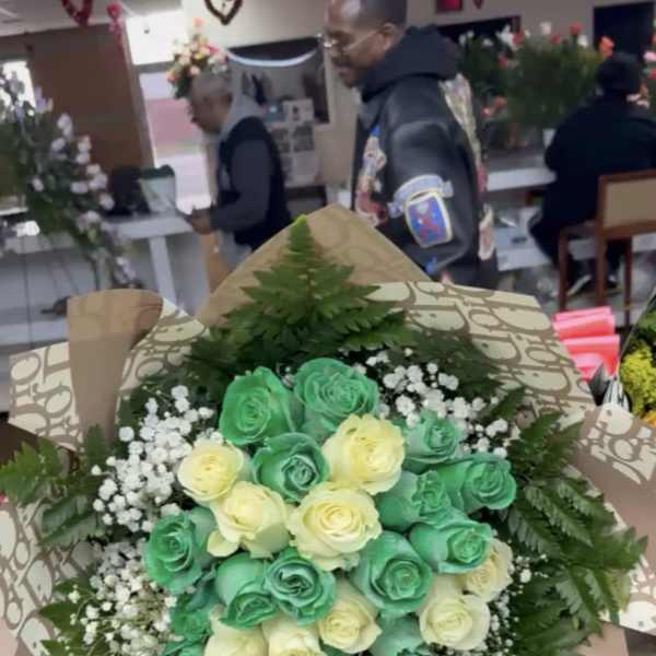 Bouquet of green and cream roses with baby's breath and fern wrapping