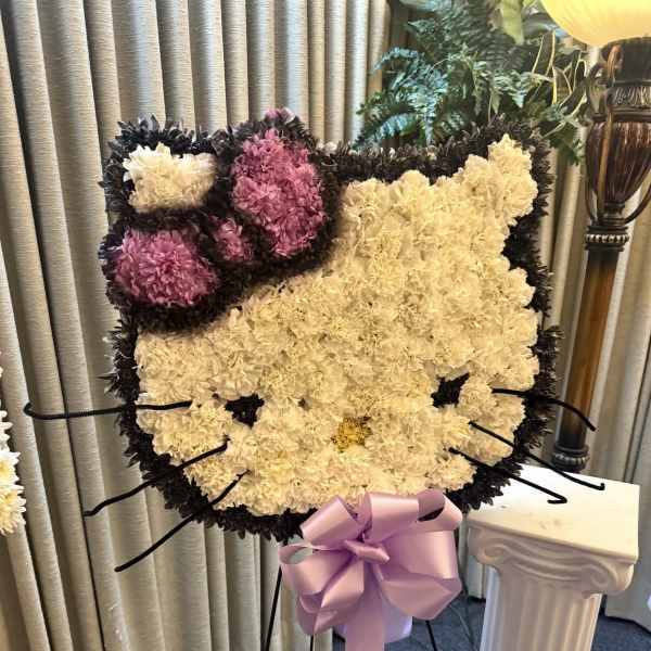 Cat-shaped floral standing spray with pink and cream carnations