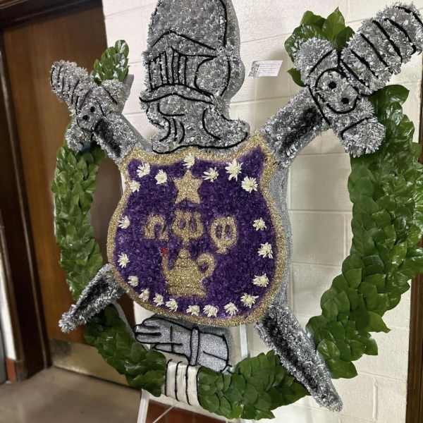 Floral standing tribute shaped like a knight in armor with a purple shield