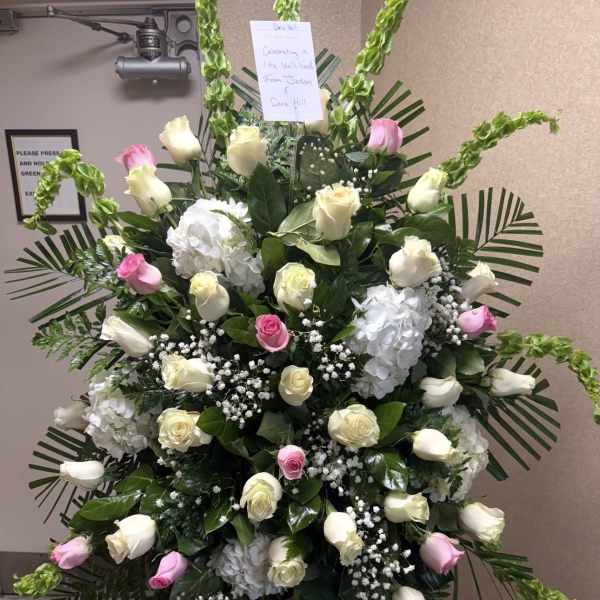 Standing spray of white and pink roses with white hydrangeas
