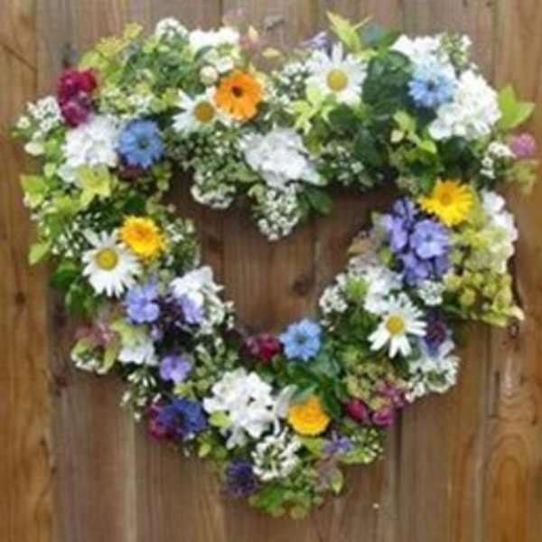 Heart-shaped floral wreath with mixed daisies and colorful blooms