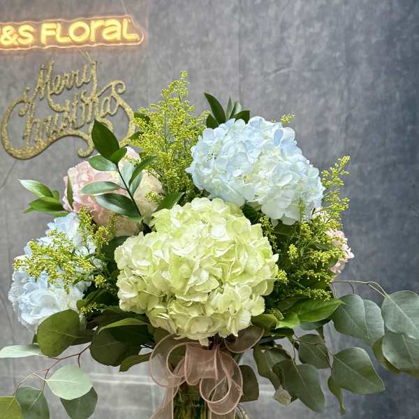 Hydrangea bouquet in a glass vase with a ribbon bow