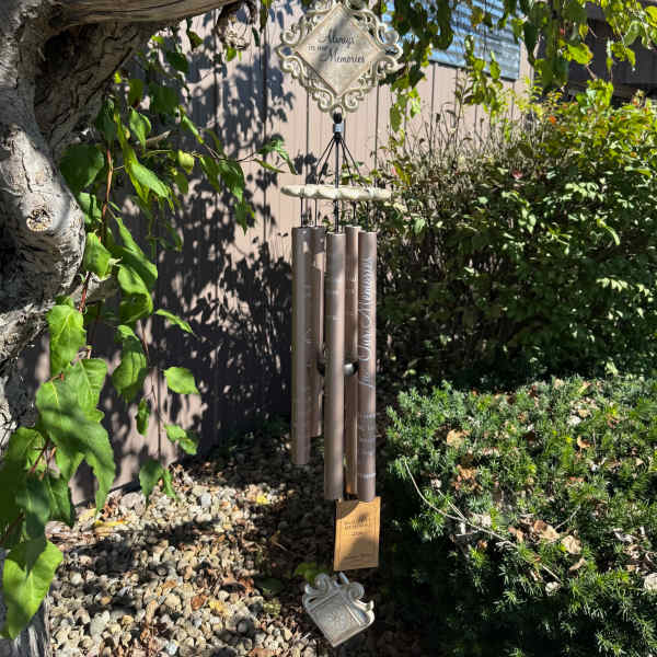 Memorial wind chime hanging from a tree in a garden