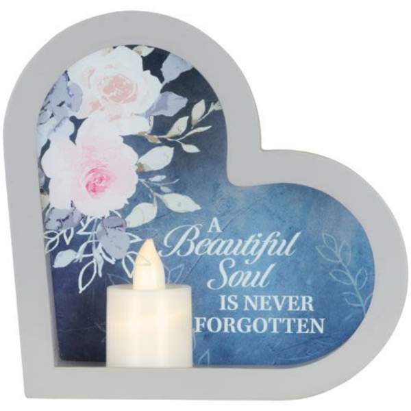 Heart-shaped memorial plaque with flowers and a candle