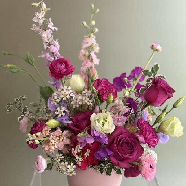 Pink and purple mixed bouquet in a pale pink vase
