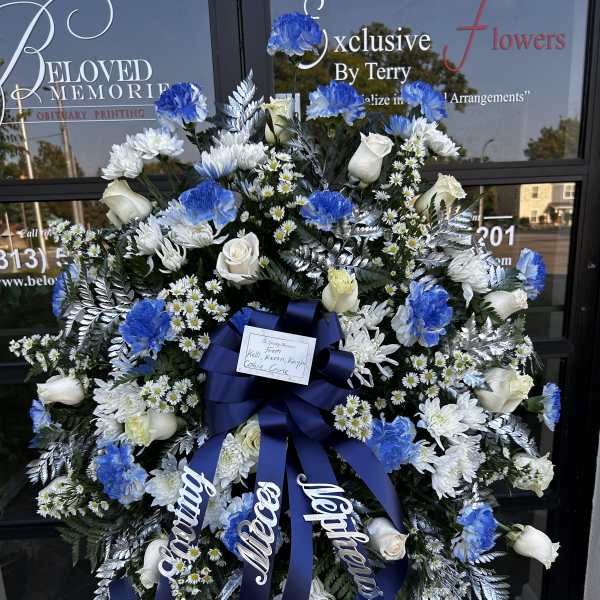 Large blue and white funeral wreath with roses and carnations