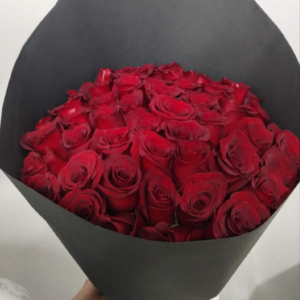 Bouquet of red roses wrapped in black paper