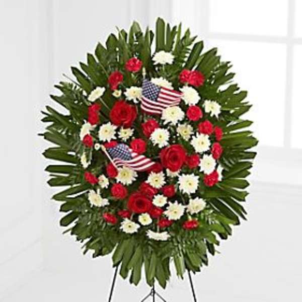 Red and white floral standing wreath with small American flags