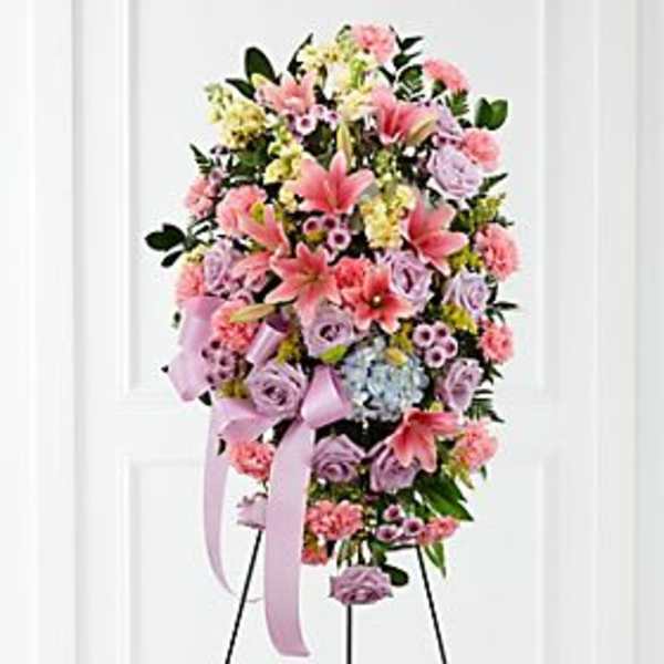 Tall standing spray of pink and lavender flowers with a ribbon