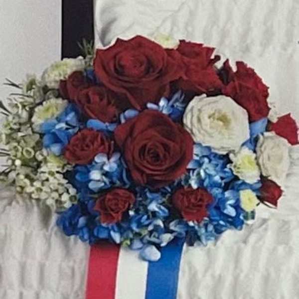 Red and white rose bouquet with blue flowers and ribbon tails
