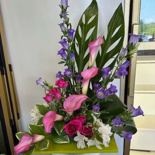 Pink calla lilies and purple bellflowers in a pedestal arrangement