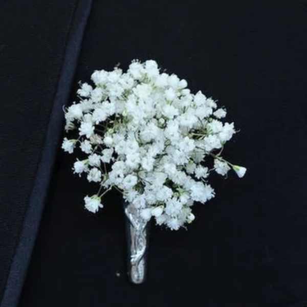 White baby's breath boutonniere on a dark suit
