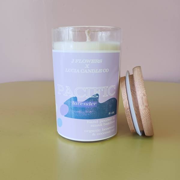 Lavender candle in a glass jar with a wooden lid beside it