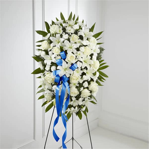 White funeral spray with blue ribbon on a stand