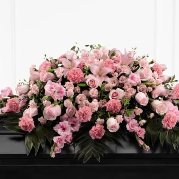 Pink floral casket spray with roses, lilies, and carnations