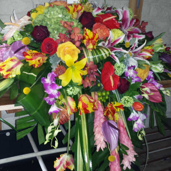 Large colorful floral spray with lilies, roses, and orchids