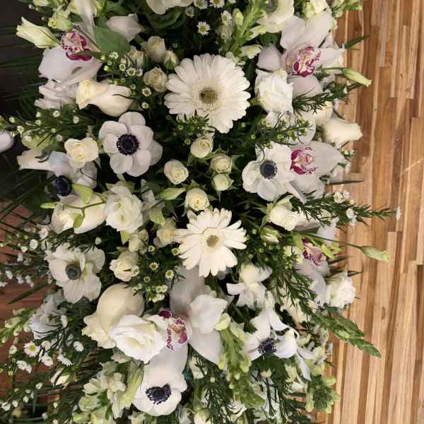 White floral spray with gerbera daisies, roses, and orchids
