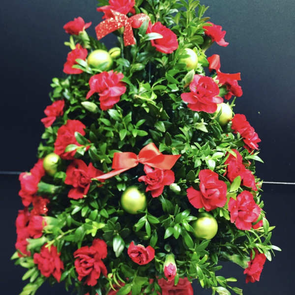 Red floral tree arrangement with green ornaments and ribbon