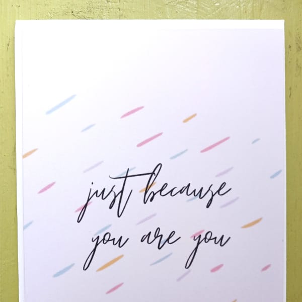 White greeting card with 'just because you are you' text and scattered pastel dashes.
