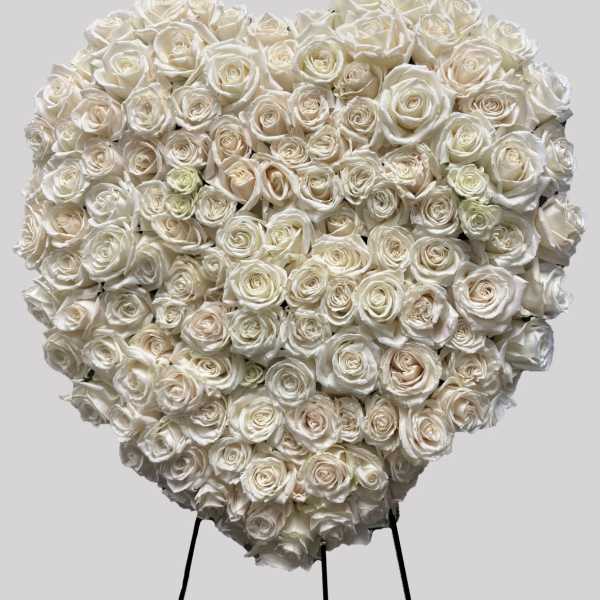 Heart-shaped arrangement of white roses on a stand
